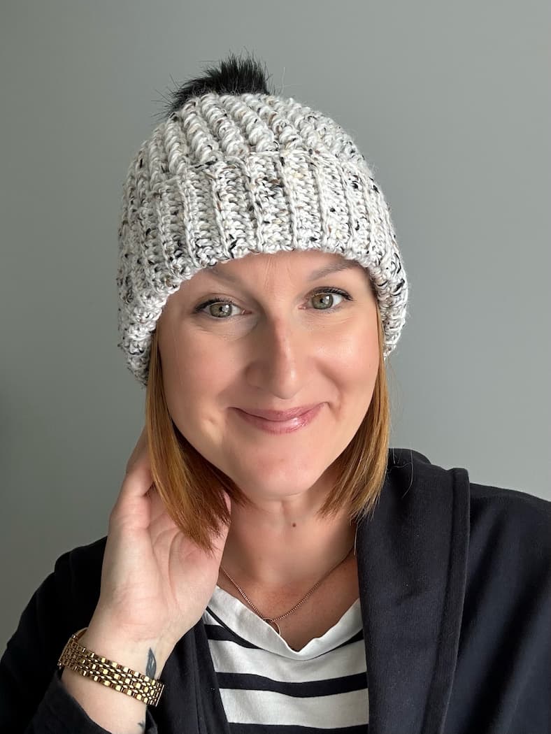 free crochet cable hat with folded brim worn as a beanie